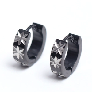 Detail shot of black stainless steel hoop earrings with silver star pattern engraving