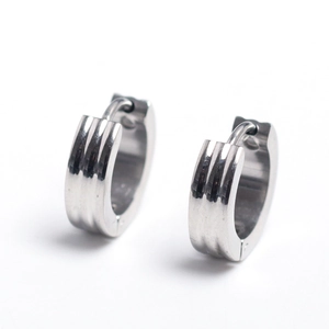Macro detail of silver stainless steel ear cuffs with industrial vertical grooved texture