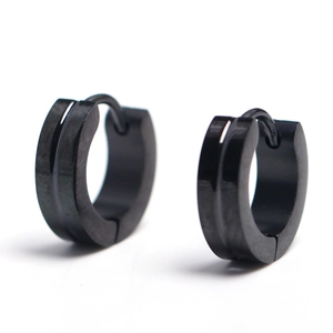 Detail view of black stainless steel huggie earrings with central groove design