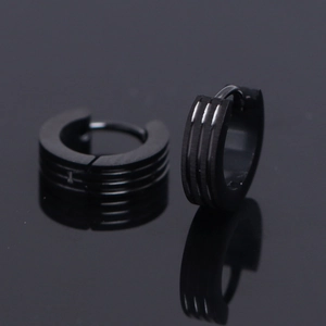 Vue macro de boucles d'oreilles créoles noires mates en acier avec triple rayure