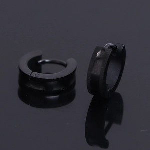 Macro shot of matte black stainless steel hoop earrings for a minimalist punk style look