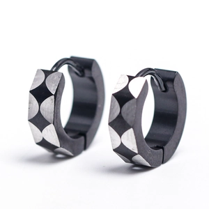 Détail de boucles d'oreilles en acier noir mat avec motif géométrique sablé argenté