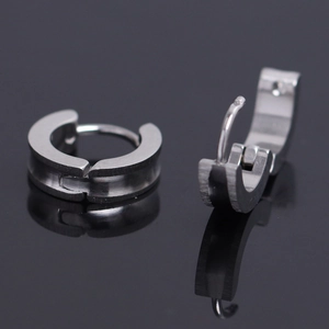 Pair of silver brushed stainless steel hoop earrings with hinged closure on black surface