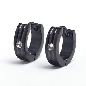 Détail macro des boucles d'oreilles noires en acier avec triple rainure et pierre CZ