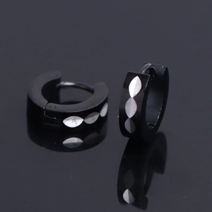Macro detail of 4mm black stainless steel hoop earrings with silver diamond pattern