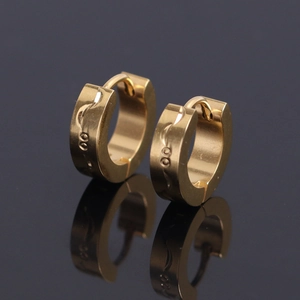 Boucles d'oreilles huggie en acier inoxydable doré avec texture gravée sur fond miroir