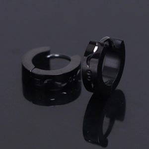Gros plan de boucles d'oreilles en acier inoxydable noir poli avec motifs gravés