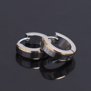 Macro view of two-tone silver and gold stainless steel hoop earrings with faceted edges