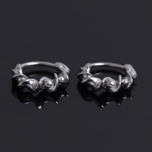 Artistic silver twisted wave hoop earrings with a textured matte finish and sleek reflection