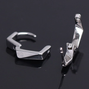 Detailed macro view of geometric silver earrings with irregular multifaceted design on black