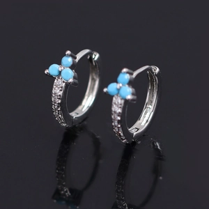 Boucles d'oreilles florales en cuivre avec turquoise et zircons sur fond sombre