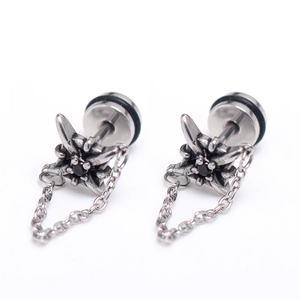 Détail de boucles d'oreilles punk argentées avec étoile noire et chaîne en métal pendante