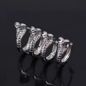 Boucles d'oreilles créoles serpent en argent avec yeux verts et noirs sur fond noir