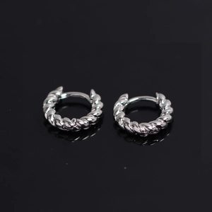 Detailed close-up of silver twisted rope hoop earrings with polished metallic texture