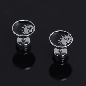 Boucles d'oreilles vintage soleil en argent et émail noir sur un fond miroir élégant