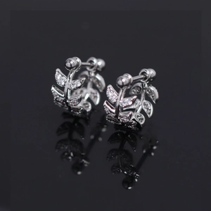 Sparkling silver leaf stud earrings with clear zircon stones on a black reflective base
