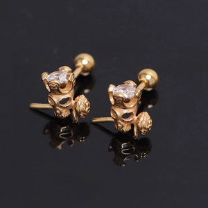Golden skull stud earrings with rose design and clear zircon stones on black background