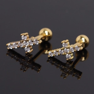 Gold cross stud earrings with sparkling cubic zirconia on a reflective black surface