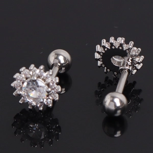 Macro detail of silver sunflower cartilage stud earrings with sparkling cubic zirconia