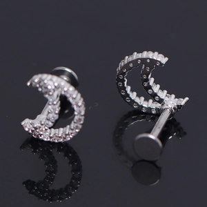 Macro shot of silver crescent moon piercing stud with sparkling pavé set cubic zirconia