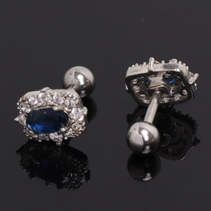 Detail view of oval sapphire stud earrings with screw-back and zircon halo on black