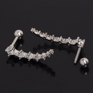 Macro detail of silver curved row earrings with sparkling cubic zirconia stones