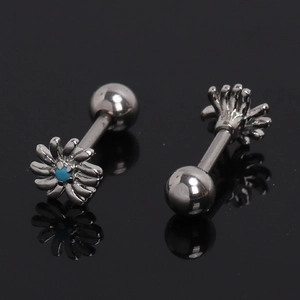 Macro detail of daisy barbell stud earrings with blue center stone on black surface