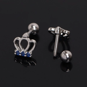 Macro view of crown-shaped silver stud earring with three blue cubic zirconia gems