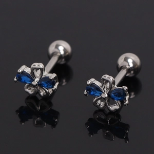 Gros plan de boucles d'oreilles fleurs avec zircons bleus et fermoir à vis en acier