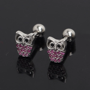 Boucles d'oreilles hibou en acier inoxydable avec strass violets sur surface noire miroir