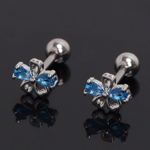Gros plan de boucles d'oreilles fleurs argentées avec pierres bleues et fermoirs à vis