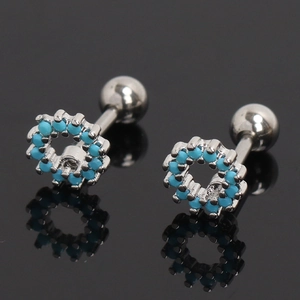 Gros plan sur des boucles d'oreilles cartilage en argent avec pierres bleues et vis à bille