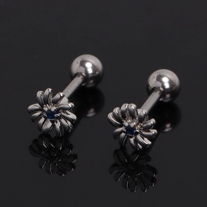 Detailed macro view of daisy stud earrings with blue center diamond and screw-back closure