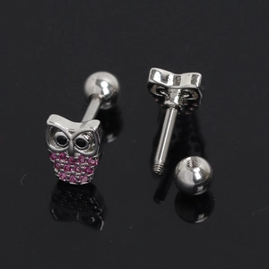 Vue macro d'une boucle d'oreille chouette avec cristaux roses et fermoir à vis sécurisé