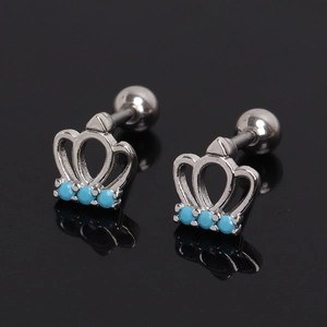 Detail of silver crown cartilage studs with blue stones and secure screw-back ball closures