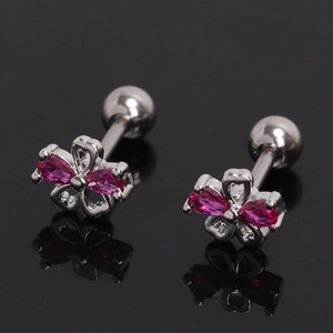 Vue macro de boucles d'oreilles fleur argentée avec cristaux roses et pétales