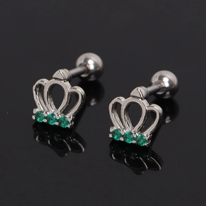 Close-up of silver crown stud earring with green crystals and screw-back on black surface