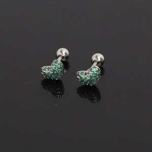 Macro shot of silver heart tragus studs with green zircon pave on black reflection