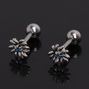 Detailed macro view of daisy stud earrings with blue zircon in polished stainless steel