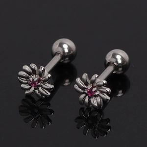 Daisy flower stud earrings in gunmetal steel with red crystal center on black surface