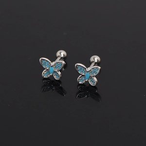 Macro dettagliata di orecchini a farfalla con pietre blu su sfondo nero con riflessi chiari