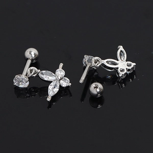 Détail macro de boucles d'oreilles papillon en argent avec zircone sur surface miroir