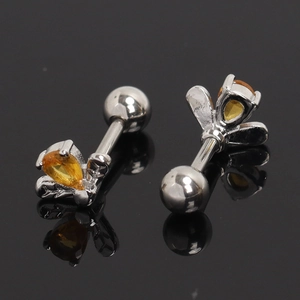 Detailed macro view of silver bee earrings with pear-cut yellow gemstones and screw backs