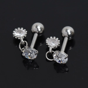 Gros plan sur des boucles d'oreilles barbell en acier argenté avec zircons brillants