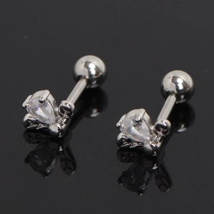 Macro shot of silver flower earrings with pear-cut zirconia on black reflective surface