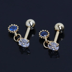 Gros plan de boucles d'oreilles en acier doré avec zircons ronds bleus et ovales clairs