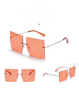 Detailed view of orange rimless square sunglasses with slim golden metal temples