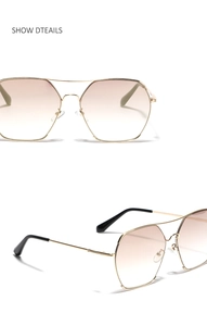 Detail view of gold metal pilot sunglasses with brown gradient lenses and double bridge