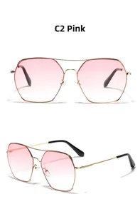 Detail view of pink gradient lenses and gold geometric metal frame pilot sunglasses