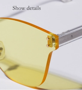 Close-up of yellow rimless sunglasses with gold metal hinges and transparent temple tips